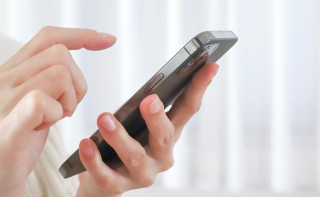 家族葬の東村山市葬儀社に電話でお問合せしようとしている人の手元。